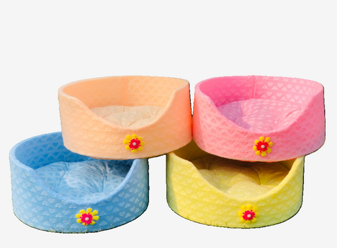 Four colorful pet beds with floral designs on a white background