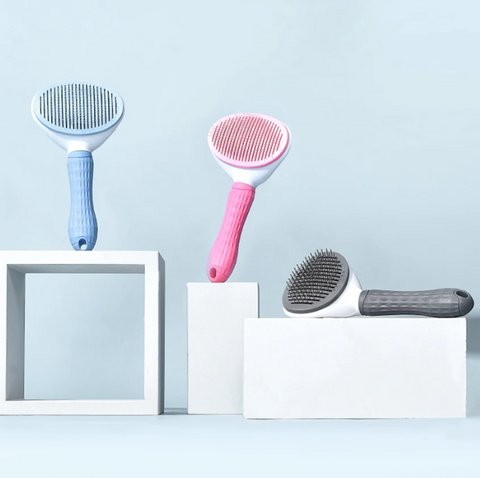 Three pet grooming brushes on a light blue background