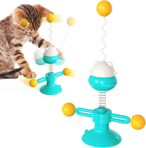 Cat playing with a colorful toy featuring spinning balls on a white background