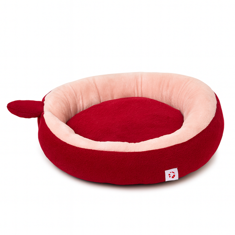 Red and pink pet bed with a small white tag on a white background