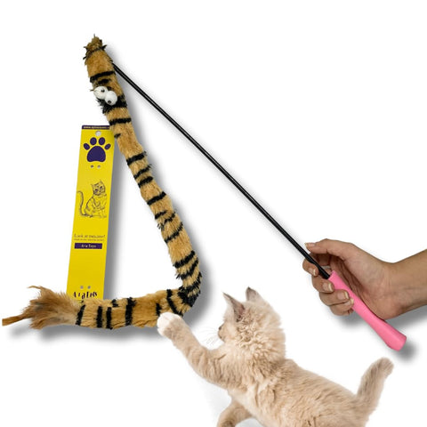 Cat toy with a tiger stripe pattern and pink handle, being used by a cat on a white background.