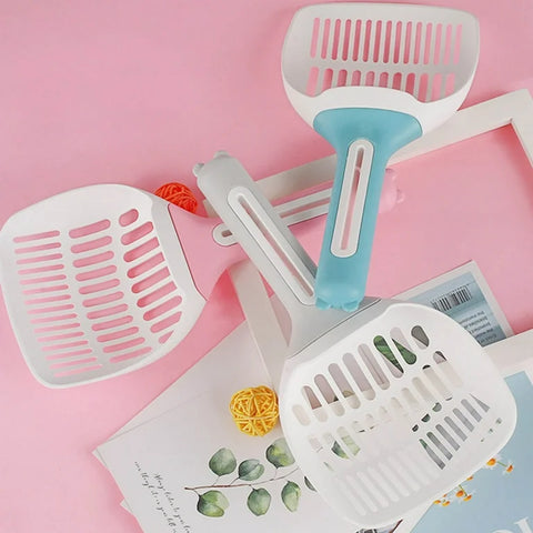 Cat litter scoops with blue and white handles on a pink background