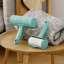 Green pet grooming tool on a wooden surface with a textured gray towel.