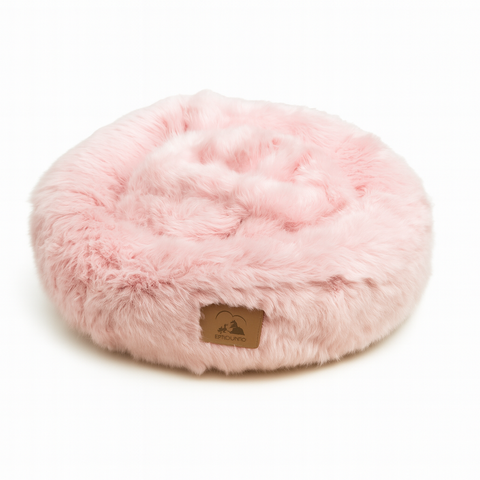 Pink fluffy pet bed with a brand logo on a white background