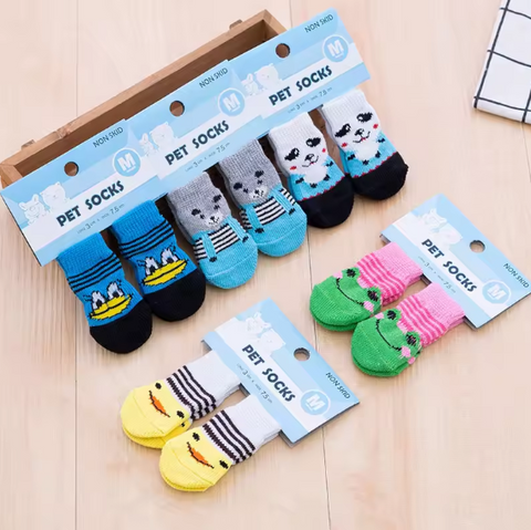 Set of cartoon pet socks with packaging on a wooden surface