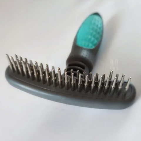 Pet grooming brush with a green handle on a white background