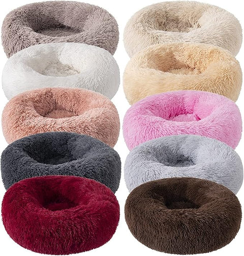 Collection of plush donut-shaped pet beds in various colors on a white background