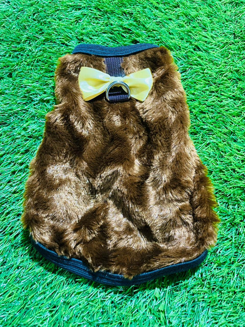Brown faux fur dog coat with a yellow bow tie on a green grass background