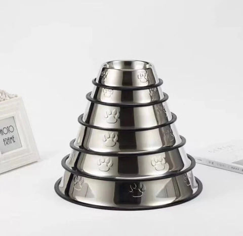 Stack of stainless steel pet bowls with paw print design on a white background